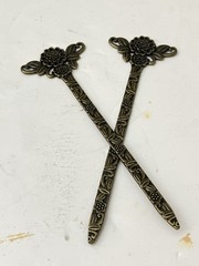 vintage-style set of 2 bronze-tone hair sticks featuring a floral design.