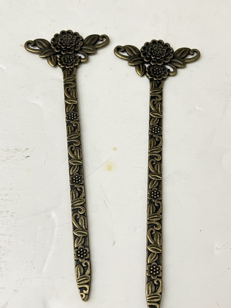 vintage-style set of 2 bronze-tone hair sticks featuring a floral design.