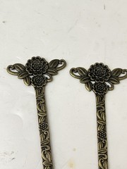 vintage-style set of 2 bronze-tone hair sticks featuring a floral design.